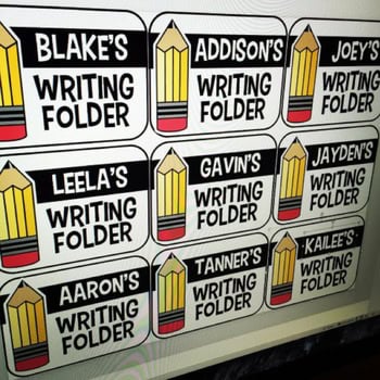 A colorful classroom display of editable writing folders labeled with student names and pencil icons, perfect for organizing student work and classroom supplies in a teacher's toolbox.