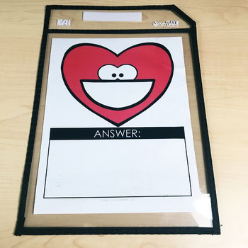 A heart-shaped toothy character on a holiday-themed Toothy® Mat with an answer box for educational and dental health activities, perfect for classroom learning and fun.