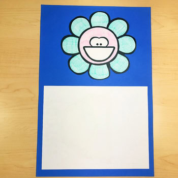 A colorful Lucky Little Learners Holiday Toothy® Mat featuring a smiling flower with a toothy grin, designed for dental health activities and fun learning for young children.
