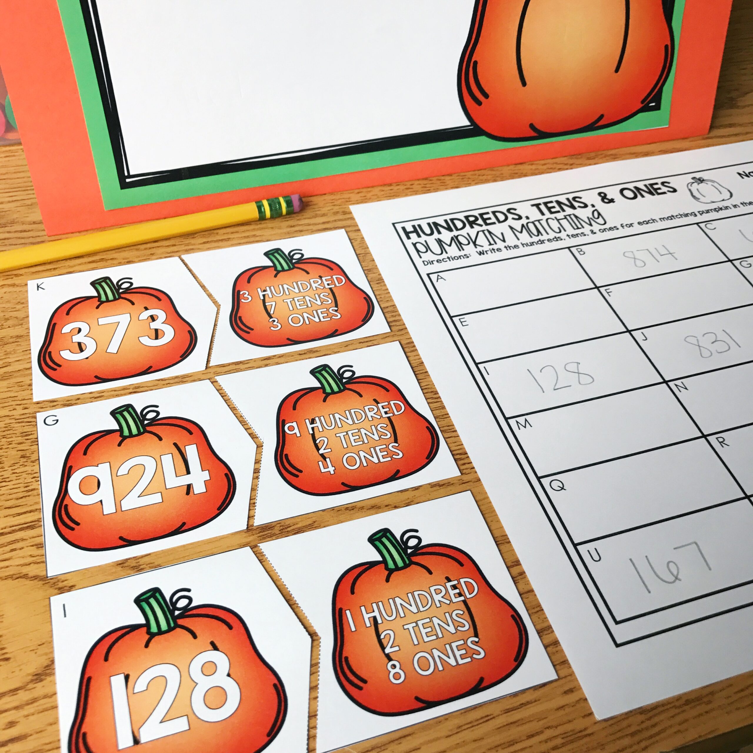 A pumpkin-themed math activity for 2nd grade, featuring hundreds, tens, and ones place value matching cards and recording sheets, perfect for October math centers and engaging students in number sens.