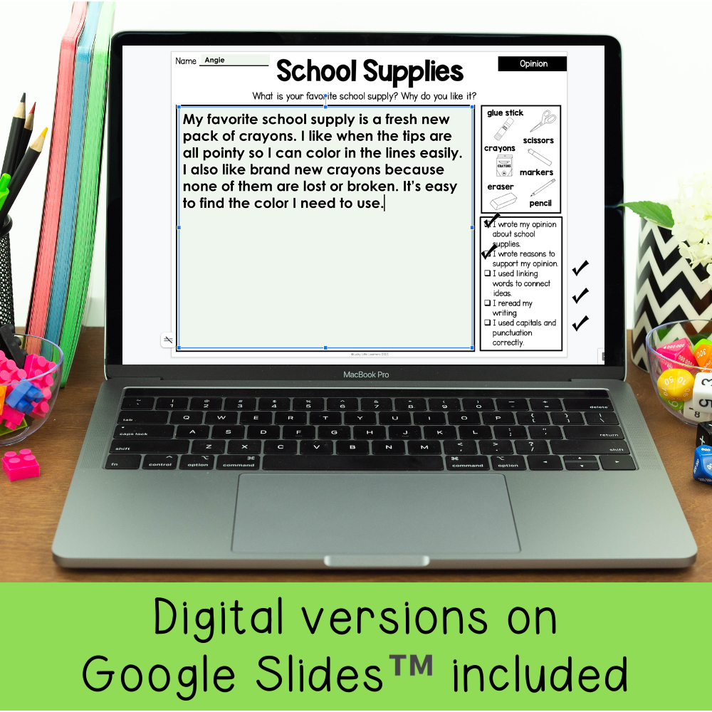 A detailed image of a laptop screen displaying a first and second grade writing prompt about school supplies, with colorful stationery around it, promoting digital and printable resources for early l.
