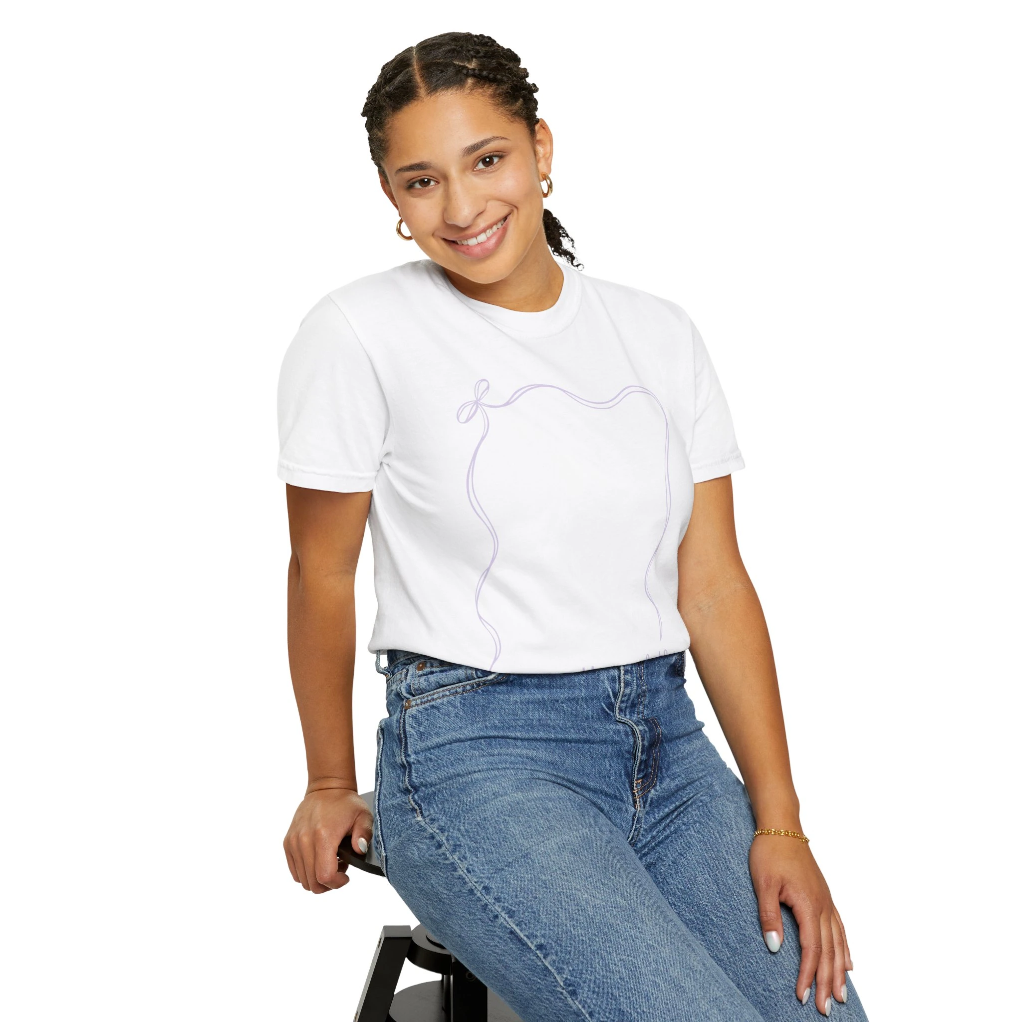 A smiling young girl wearing a white 2nd grade autograph T-shirt with a purple outline of a bear, sitting on a stool, celebrating the end of the school year, perfect teacher wearable keepsake.