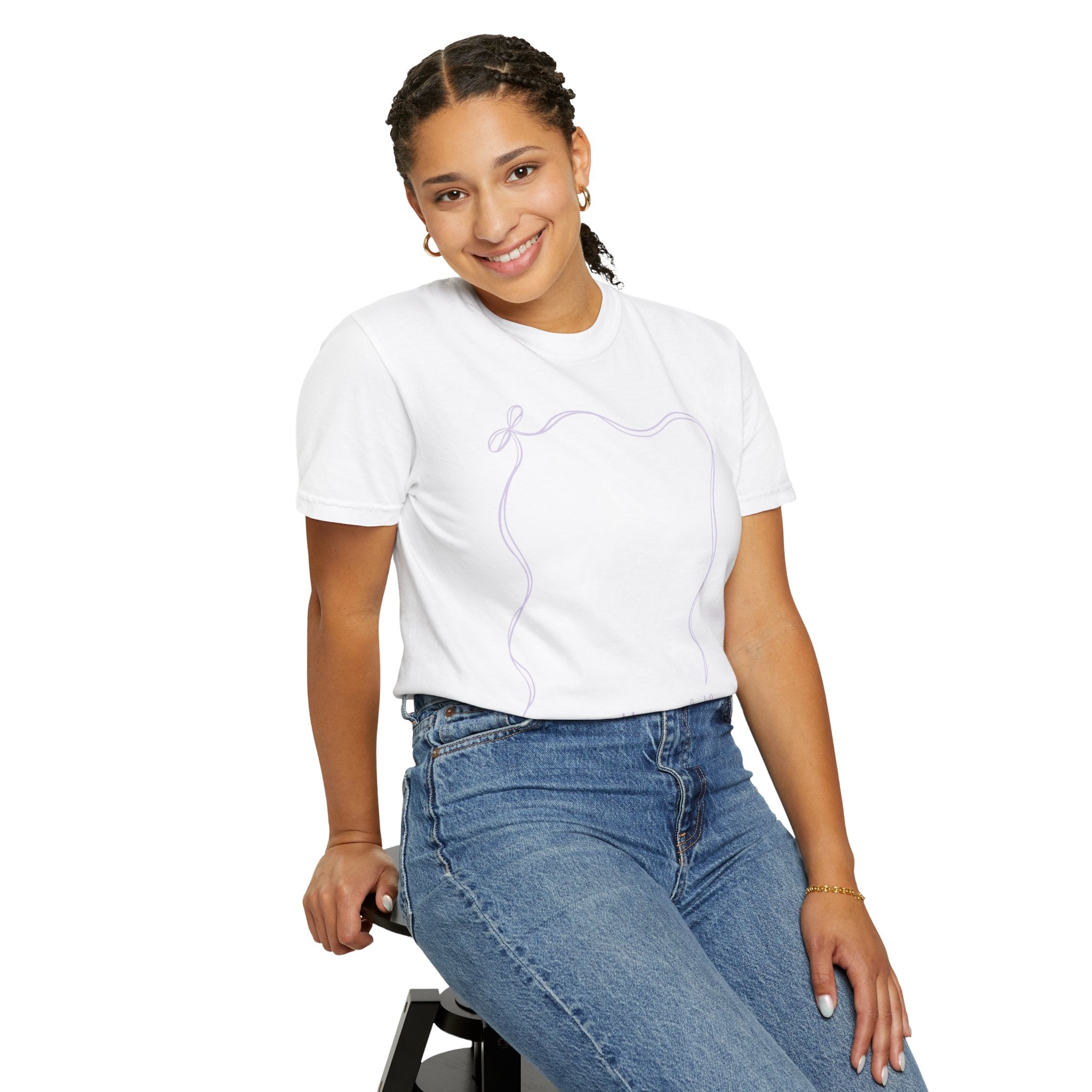 A smiling young girl wearing a white autograph T-shirt with a purple signature design, sitting on a stool, showcasing a fun and memorable teacher wearable year-end keepsake for students and educators.